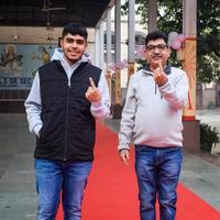 New Delhi, India - December 04 2022 - Unidentified people showing their ink-marked fingers after casting votes in front of polling booth of east Delhi area for MCD local body Elections 2022 photo