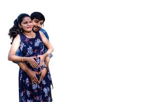 pareja india posando para una sesión de maternidad con fondo blanco liso. la pareja está posando en un césped con hierba verde y la mujer está faluntando su panza en el jardín lodhi en nueva delhi, india foto