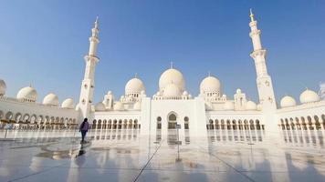 abu dhabi, uae, 2022 - turist promenad runt om sheikh zayed moské i klar blå himmel dag, abu dhabi, förenad arab emirates video