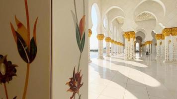 abu dhabi, emiratos árabes unidos, 2022 - cerrar flores en columnas detalles exteriores de arte en la gran mezquita. pasillos de la gran mezquita sin nadie a la luz del sol brillante video