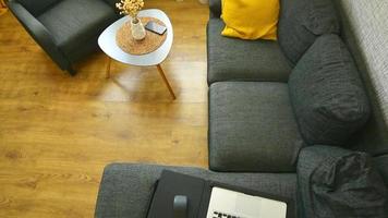 laptop computer door koffie tafel, portable bureau Aan grijs sofa met geel kussens. afgelegen werk Bij huis kantoor.helder positief uitstraling inspiratie ontspannende werken huis ruimte video