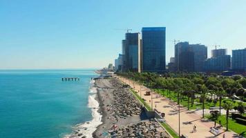 Aerial side view tourist in Batumi enjoy summer in hot sunny day with background of hotel buildings video