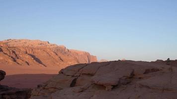 kvinna turist stå på klippa på synpunkt njut av wadi rom panorama på soluppgång. wadi rom öken- - dal wadi saabit. jordan utforska begrepp video