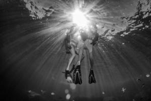 hermoso buzo bajo el agua con rayos de sol foto