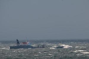 A ship seems to sink in the big waves of the arctic ocean tempest photo