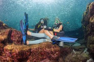 beautiful girls looking at you while swimming underwater photo