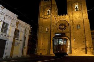 vista nocturna de la catedral de lisboa con tranvía foto