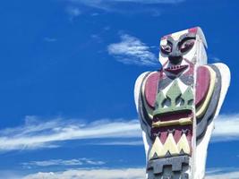 A totem wood pole in the blue cloudy background photo