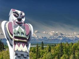 A totem wood pole in mountain background photo