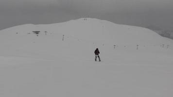 jong snowboarder freeriden bergafwaarts in toneel- Kaukasus bergen in slecht weer staat en slecht zichtbaarheid. gevaren en extreem winter weerr sneeuw voorwaarden video