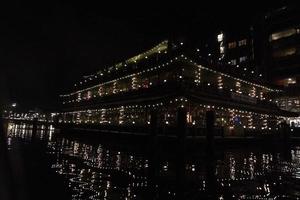 amsterdam canal at night view floating restaurant photo