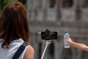 Selfie con smartphone en la fontana de Trevi llena de turistas Roma Italia foto