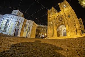 vista nocturna de la catedral de lisboa con tranvía foto