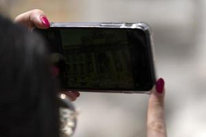 turista tomando selfie en fontana di trevi fontana roma foto