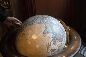 Hand touching earth globe photo