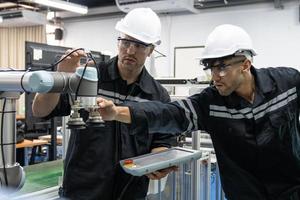 Two Diverse Professional Heavy Industry Engineers Wearing Safety Uniform and Hard Hats Working Industry and engineering people technology concept . photo