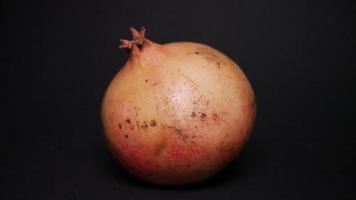 Ripe pomegranate   on  a black background photo