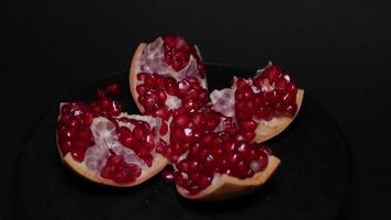 Ripe pomegranate   on  a black background photo