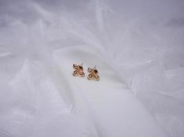 Beautiful gold earrings close-up on a white background photo