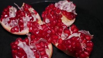 Ripe pomegranate   on  a black background photo