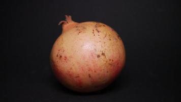 Ripe pomegranate   on  a black background photo