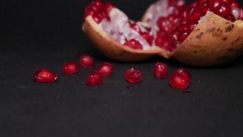 Ripe pomegranate   on  a black background photo