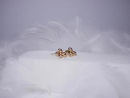 Beautiful gold earrings close-up on a white background photo