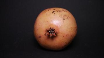 Ripe pomegranate   on  a black background photo