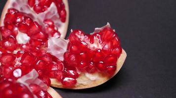 Ripe pomegranate   on  a black background photo