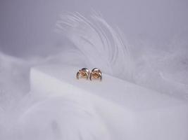 Beautiful gold earrings close-up on a white background photo