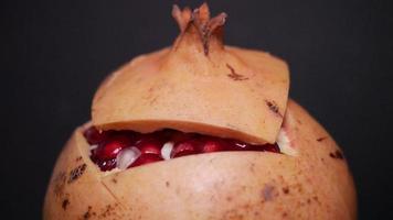 Ripe pomegranate   on  a black background photo