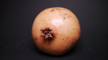 Ripe pomegranate   on  a black background photo