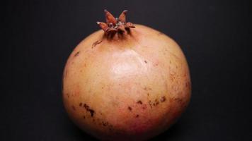 Ripe pomegranate   on  a black background photo