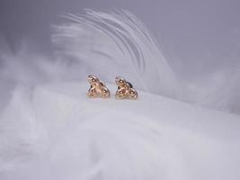 Beautiful gold earrings close-up on a white background photo