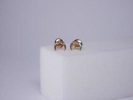 Beautiful gold earrings close-up on a white background photo