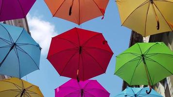 Walking under colored umbrellas. Bottom to top view. Slow motion footage video