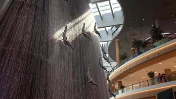 dubai, Unidos árabe emirados, 2022 - cascata e escultural composição do pérola mergulhadores ou caindo, vôo pessoas dentro a dubai Shopping video
