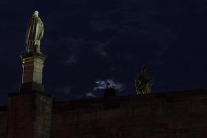 Prague charles bridge at moon light night photo