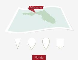 Curved paper map of Florida state with capital Tallahassee on Gray Background. Four different Map pin set. vector