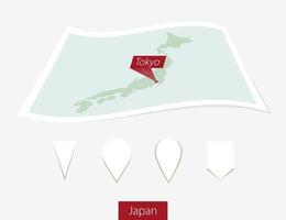 Curved paper map of Japan with capital Tokyo on Gray Background. Four different Map pin set. vector