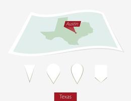 Curved paper map of Texas state with capital Austin on Gray Background. Four different Map pin set. vector