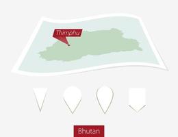 Curved paper map of Bhutan with capital Thimphu on Gray Background. Four different Map pin set. vector