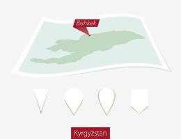 curvo papel mapa de Kirguistán con capital bishkek en gris antecedentes. cuatro diferente mapa alfiler colocar. vector