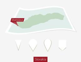 Curved paper map of Slovakia with capital Bratislava on Gray Background. Four different Map pin set. vector