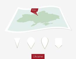 Curved paper map of Ukraine with capital Kiev on Gray Background. Four different Map pin set. vector