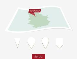 Curved paper map of Serbia with capital Belgrade on Gray Background. Four different Map pin set. vector