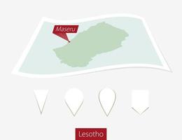 Curved paper map of Lesotho with capital Maseru on Gray Background. Four different Map pin set. vector