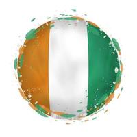 Round grunge flag of Ivory Coast with splashes in flag color. vector