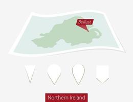 Curved paper map of Northern Ireland with capital Belfast on Gray Background. Four different Map pin set. vector