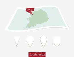 curvo papel mapa de sur Corea con capital Seúl en gris antecedentes. cuatro diferente mapa alfiler colocar.